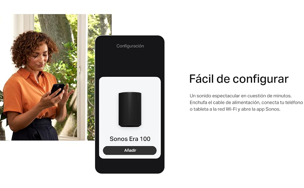 una mujer de pie frente a una ventana con un teléfono.
