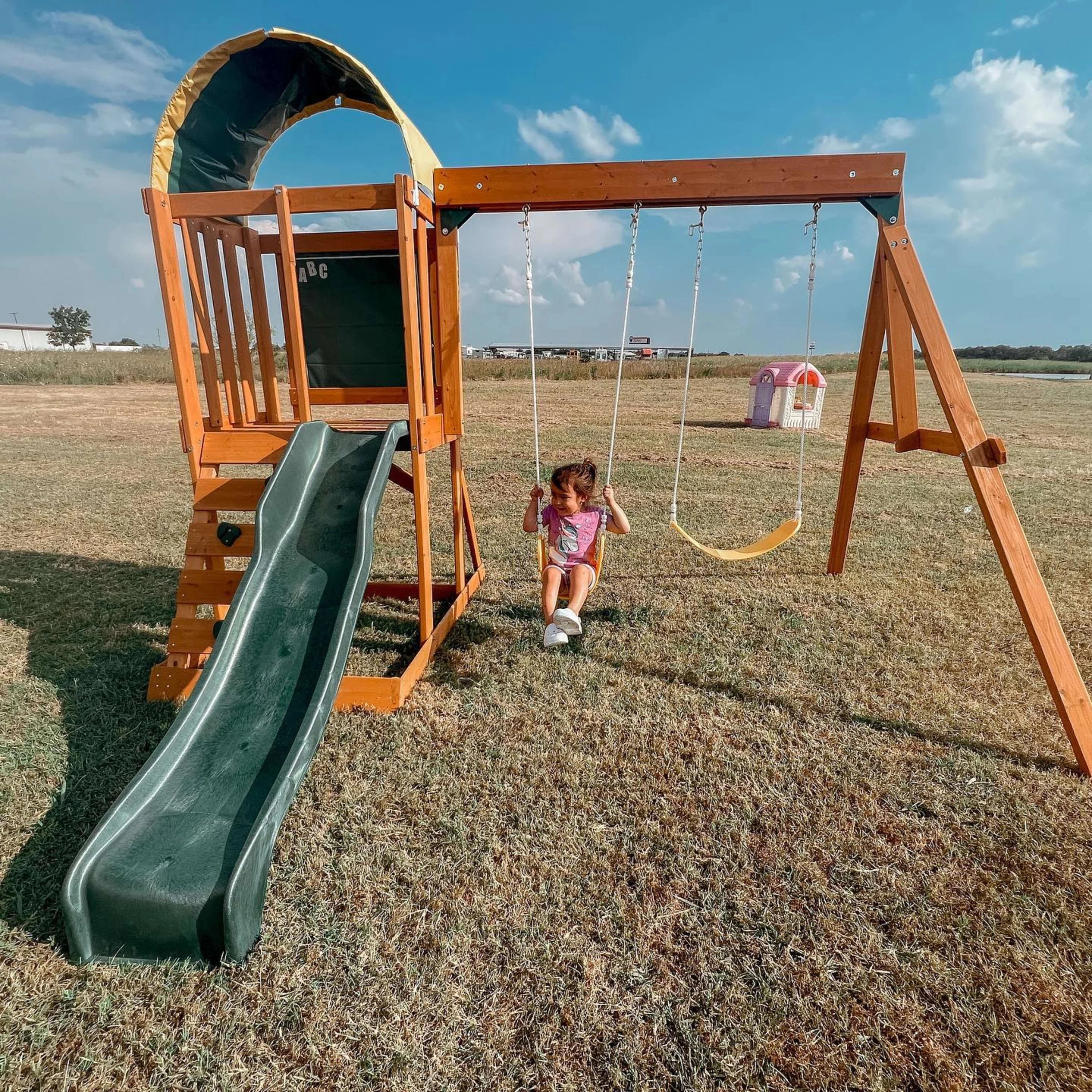 El conjunto de juegos al aire libre KidKraft Ainsley con resbaladilla y pared para escalar
